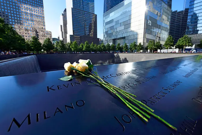 Flowers on the ledge of one of the pools of the 9/11 Memorial